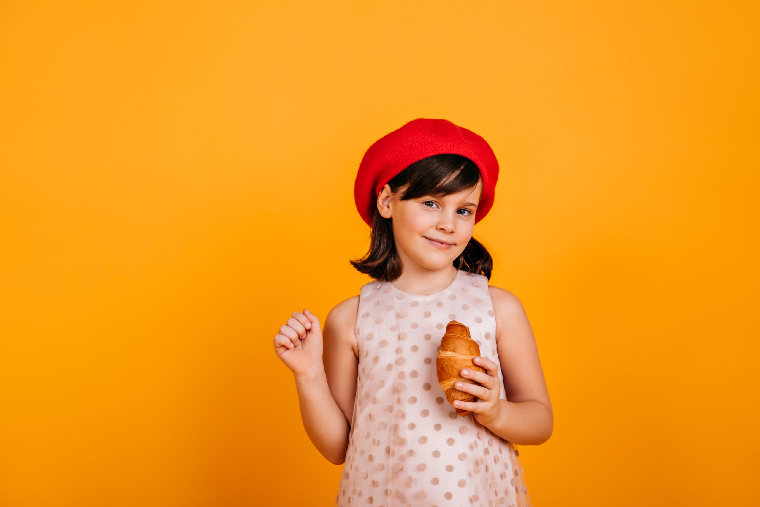 French little girl eating un croissant